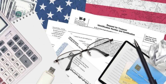 Image of tax forms neatly arranged with a pen and eyeglasses on top, illustrating the preparation needed for tax season and the expert advice offered by Juna Financial Solutions to successfully navigate it.
