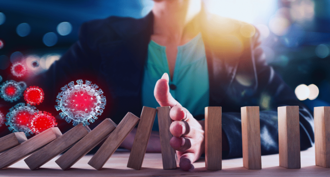 Image of a determined businesswoman strategically aligning dominos amidst illustrations of the COVID-19 virus, symbolizing her resilience and strategic planning in navigating the challenges of the pandemic in the business world.